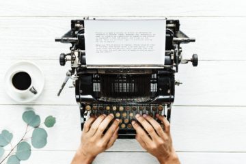 top view of a person typing on a vintage typewriter