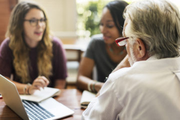 senior professor giving advice to two of his students