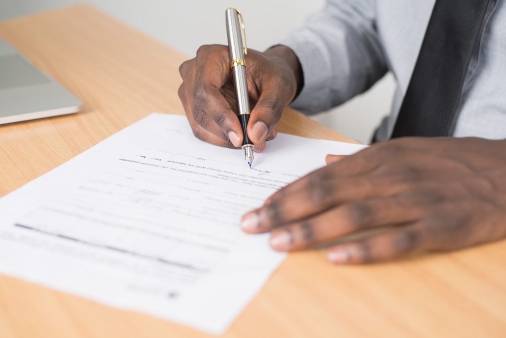 close up shot african american man signing a document