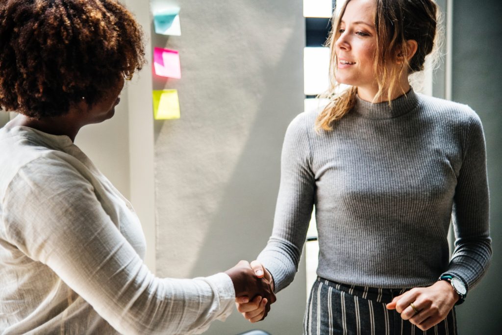 two women shaking hands