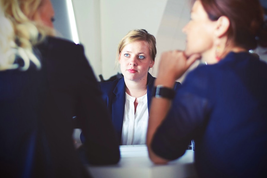 woman with blonde hair and blue eyes being interviewed for a job