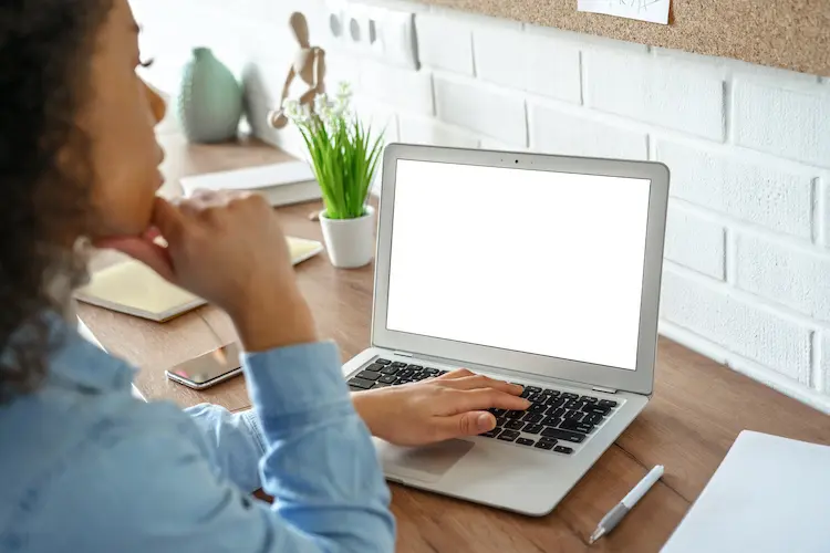 woman with curly hair looking at her laptop