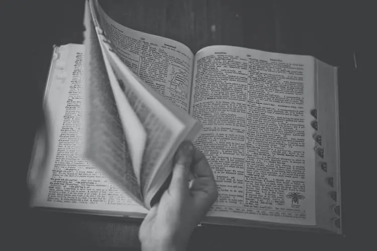 black and white photography of a person flipping through a book