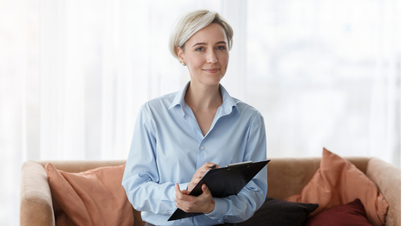 psychologist holding a notepad and smiling towards the camera