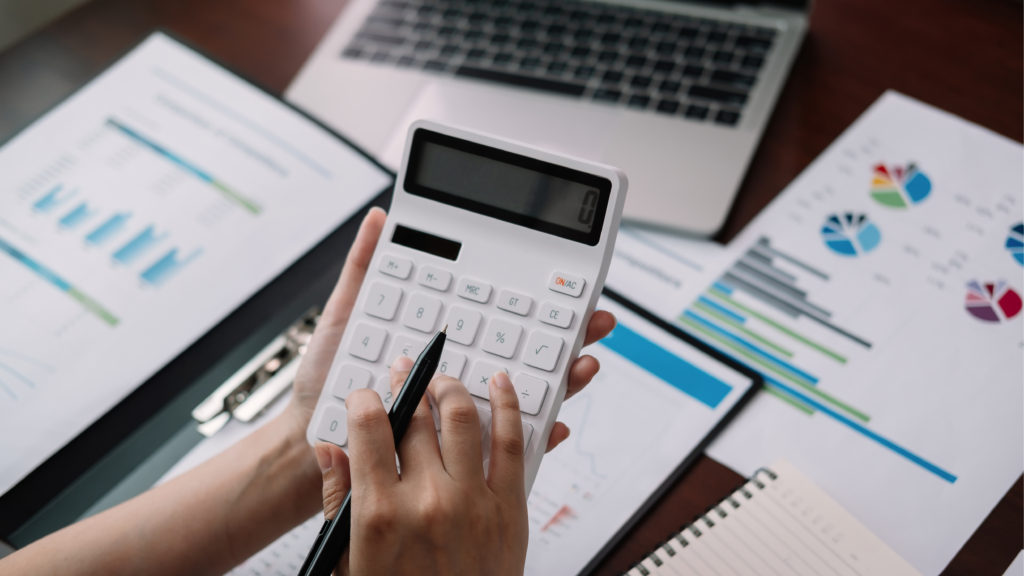 woman using a calculator to analyze data