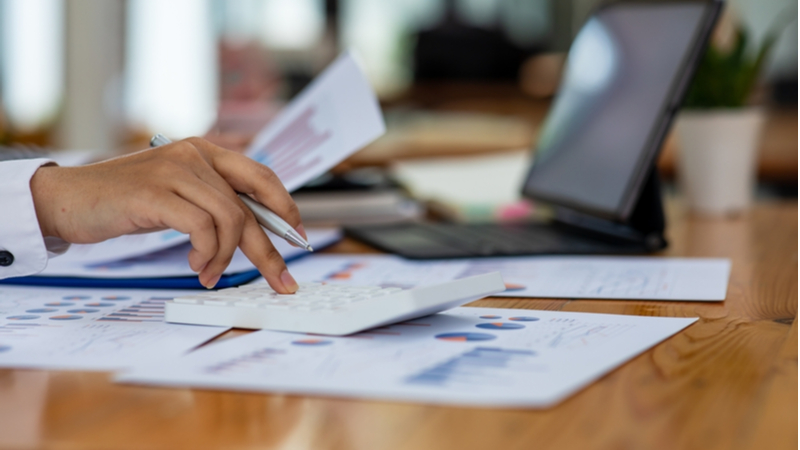 woman going through statistics charts in front of her laptop