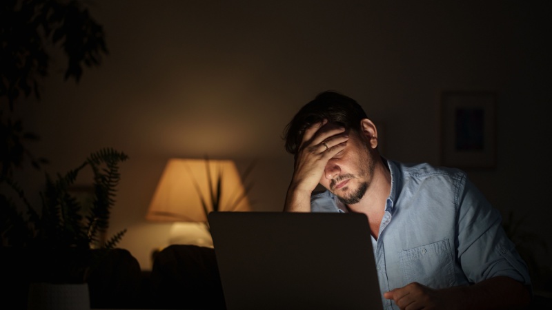 tired phd student looking at laptop screen